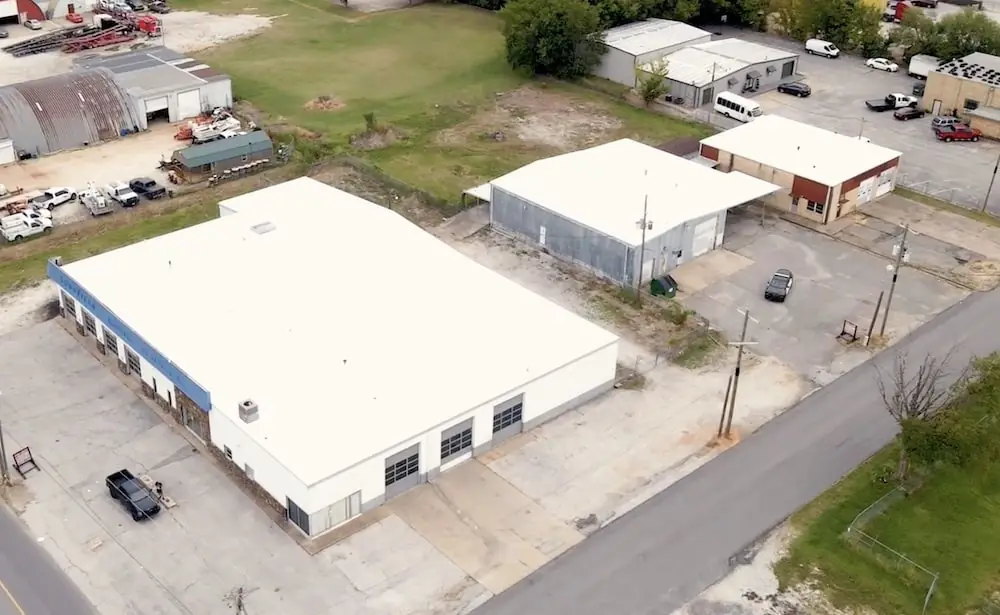 Drone view of a commercial building with a new white single-ply flat roof
