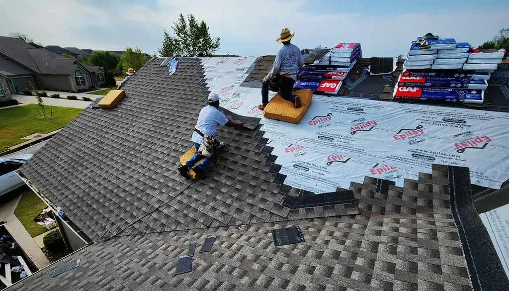 Superior Roofing crew laying new shingles over white underlayment, bundles staged on the ridge